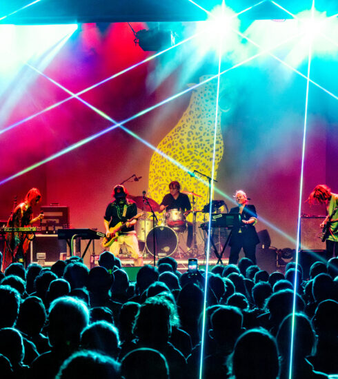 Aircooled on stage in front of a huge crowd with bright colours and lazers