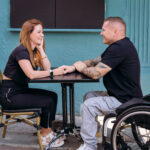 Athlete Chris Weir in a wheel chair at a table with his girlfriend sitting opposite. Both looking very much in love