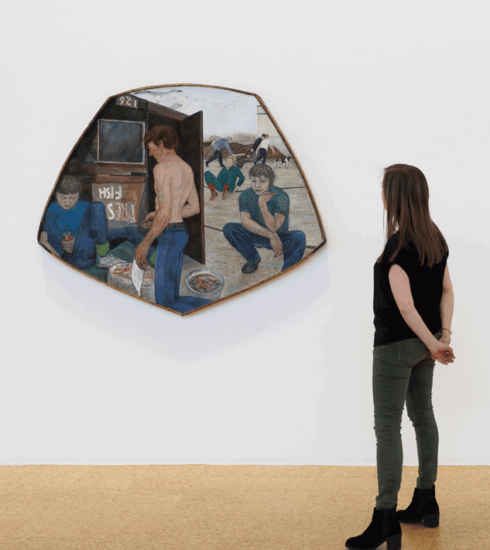 A person stands looking at a painting by Laetitia Yhap which is painted on an abstract canvas on teh walls of the De La Warr Pavilion